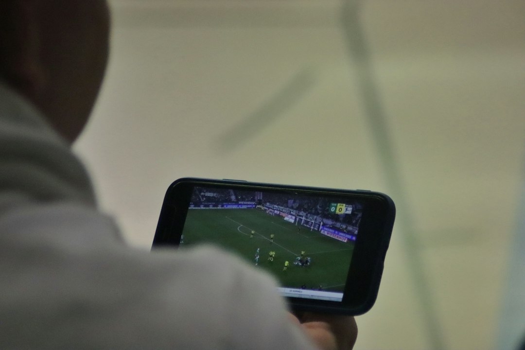 Sites de apostas — imagem ilustrativa Pessoa usando celular com jogo de futebol, imagem ilustrativa sobre sites de apostas
